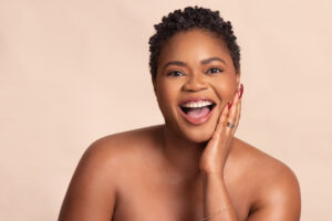 Woman smiles at camera for OLORI Beauty USA's launch campaign, photographed by Remi Adetiba