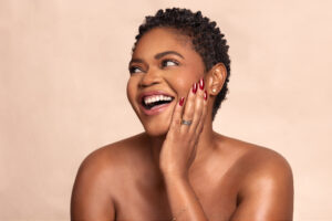 Woman smiles at camera for OLORI Beauty USA's launch campaign, photographed by Remi Adetiba