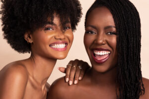 Two women laugh, photographed by Remi Adetiba for OLORI Beauty USA's launch campaign
